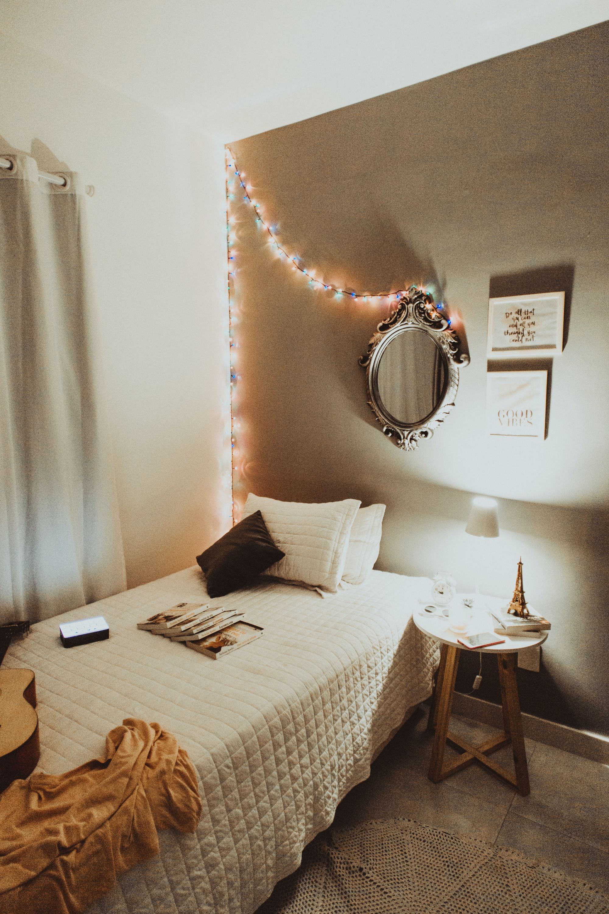 a picture of a bedroom including a bed and a nightstand with a guitar laying on the bed