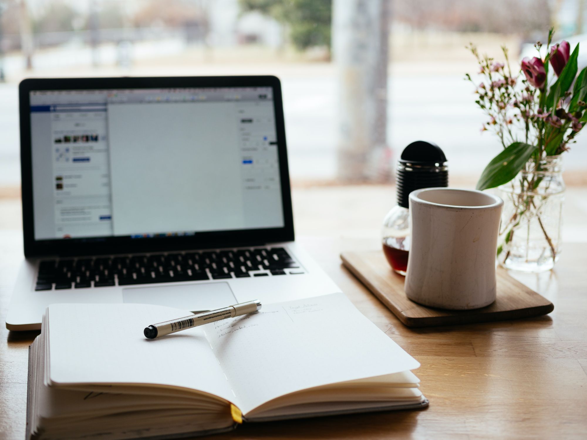 A picture of a laptop and a notebook on a desk