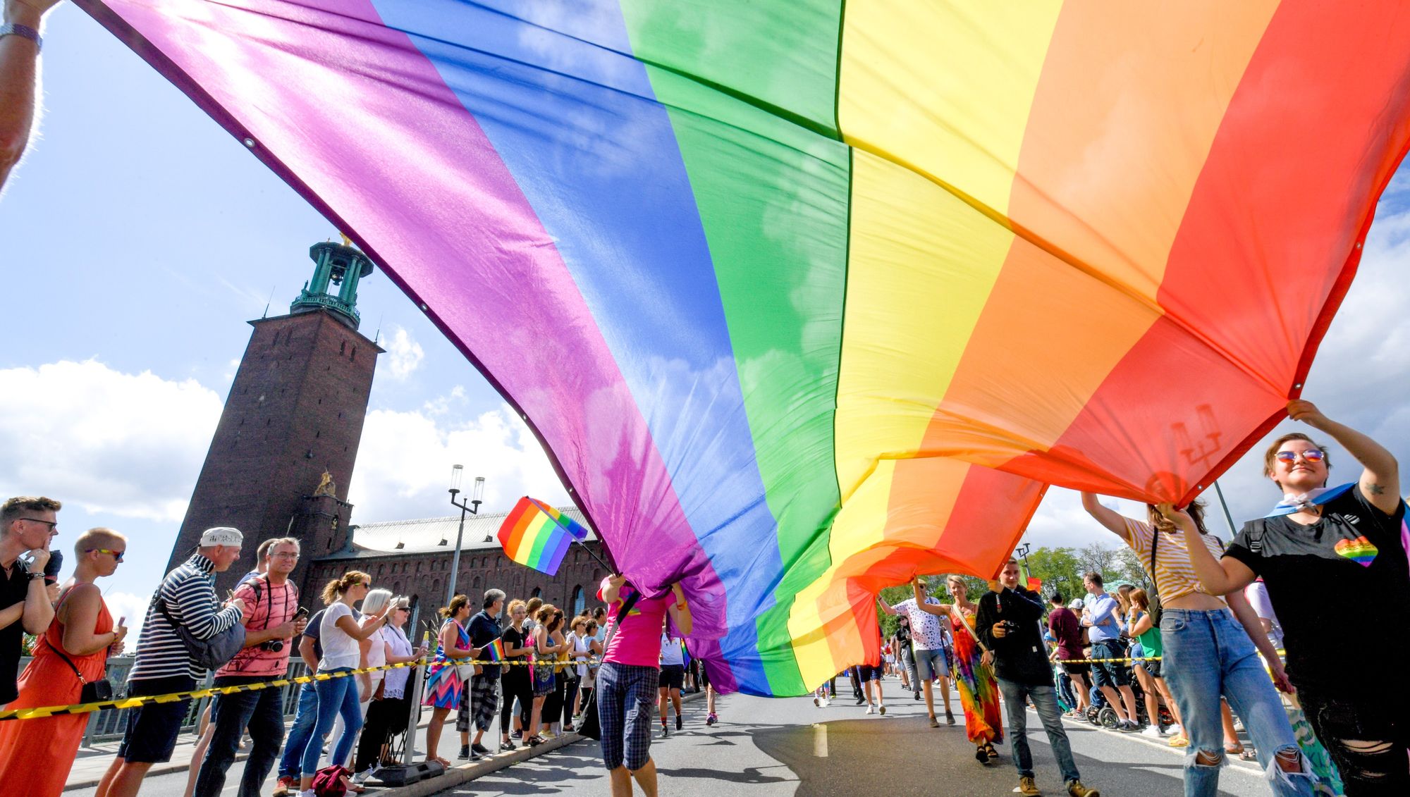 Photo of a group of people carrying a large pride flag at Stockholm's annual Pride Festival