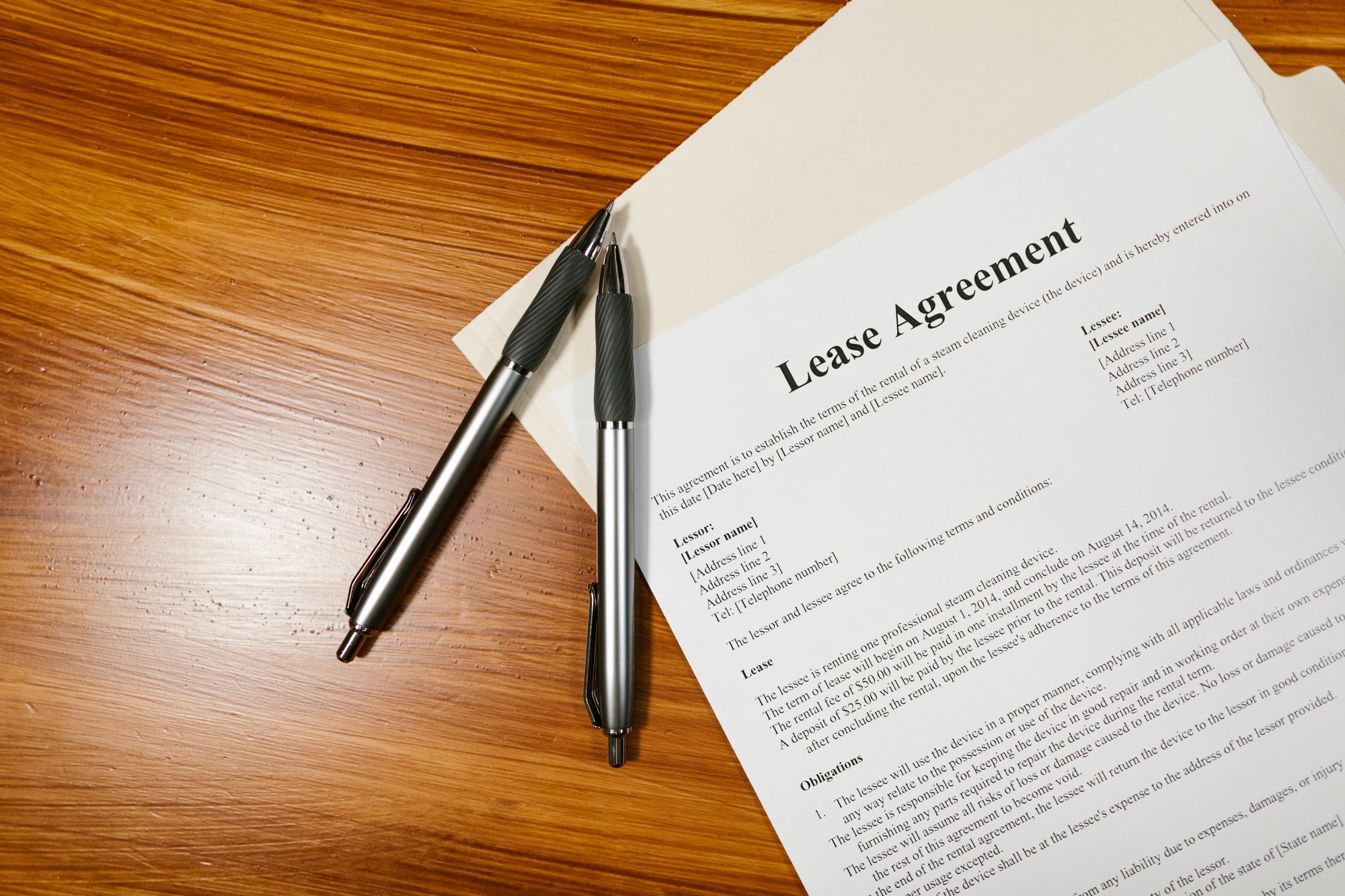 Photo of a printed lease agreement alongside two pens