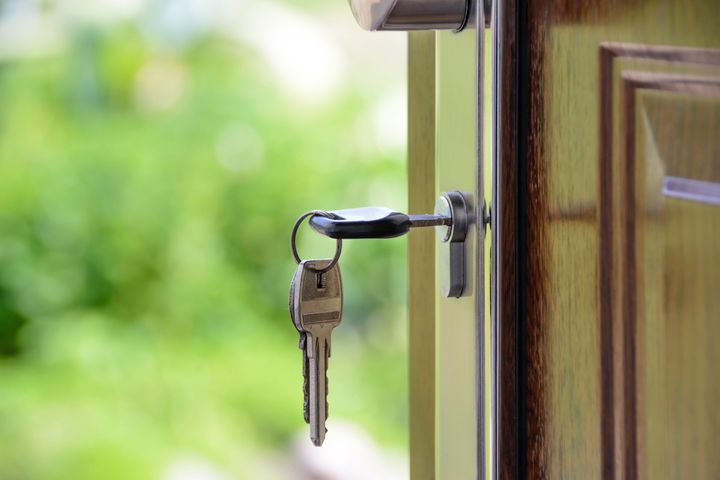 Black handled key in a key whole on a door