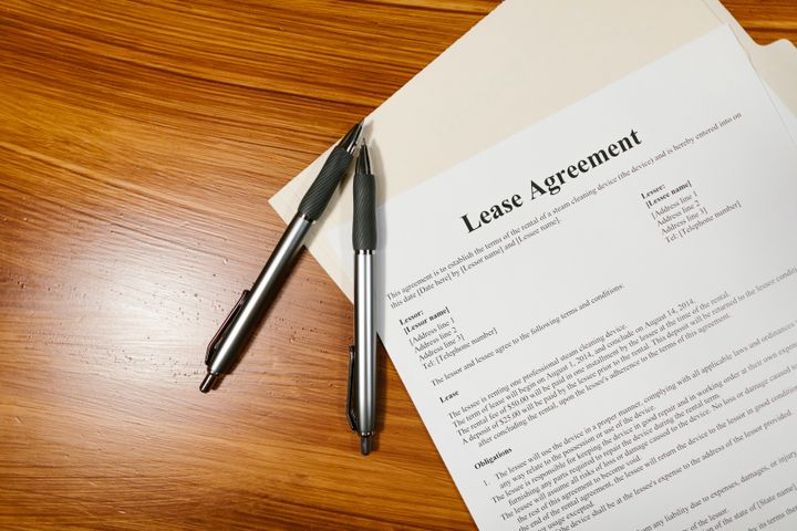 A printed lease agreement, with two pens next to it