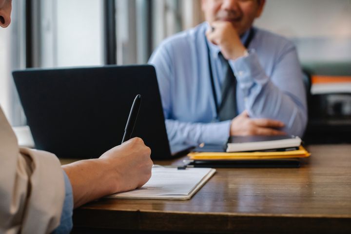 Two people signing an agreement.