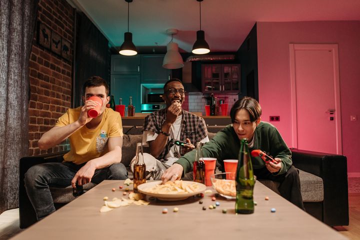 A group of roommates playing videogames at home