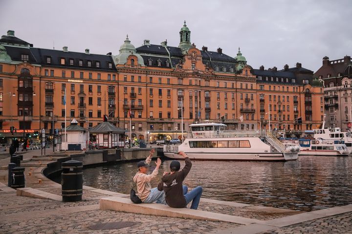 A photo of two students sitting in front of Östermalm's Strandvägen