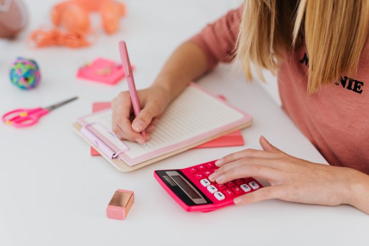 Girl solving an equation and holding a calculator