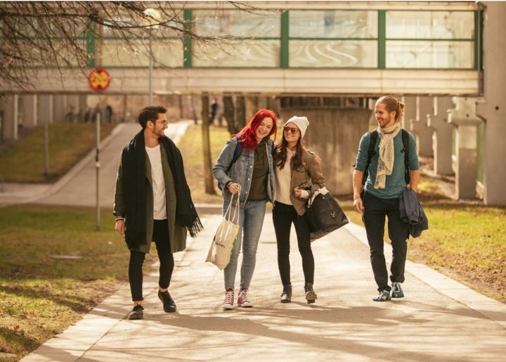 A group of four students walking down a pathway in Stockholm University, located in Stockholm, Sweden