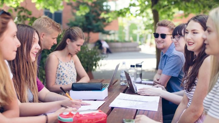 A group of exchange students sits at a table on campus at Aarhus University in Aarhus, Denmark