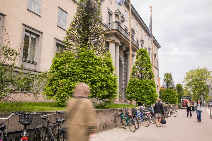 A row of bikes and students walking around on campus at the Stockholm School of Economics in Sweden