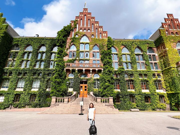 A student stands in front of the recognizable campus building at Lund University in Sweden
