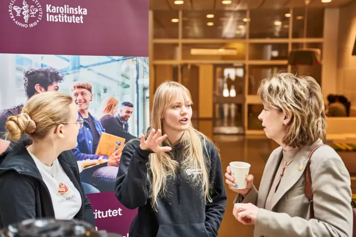 Two students speaking to a faculty member at Karolinska Institutet in Stockholm, Sweden