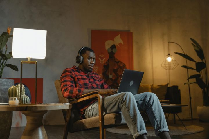 Man sitting on an armchair while using his laptop