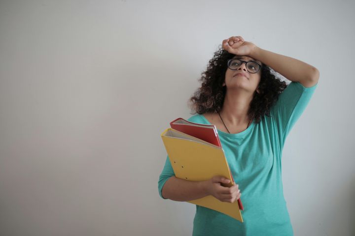 Overworked adult female entrepreneur with papers in light modern office